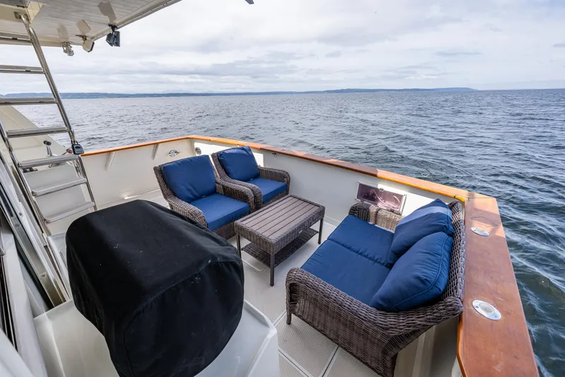 Slide: The Image of 1997 Offshore Yachts 52 Sedan deck with wicker seating, ocean view. - 38