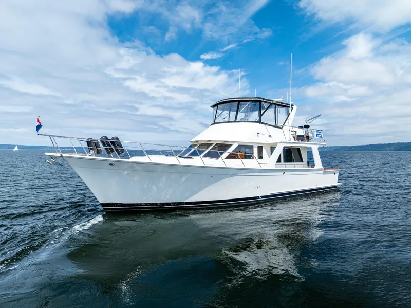 Slide: The Image of 1997 Offshore Yachts 52 Sedan cruising on open water under a partly cloudy sky. - 4