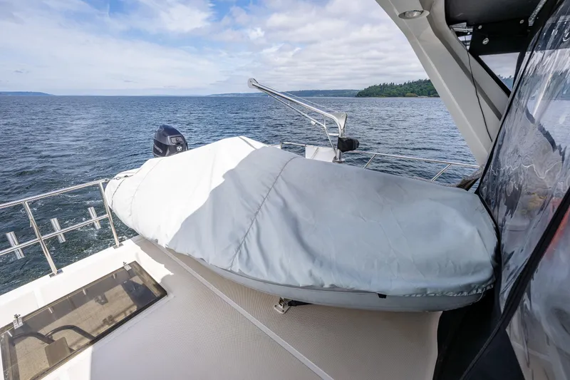 Slide: The Image of 1997 Offshore Yachts 52 Sedan deck with covered equipment, overlooking serene ocean view. - 46