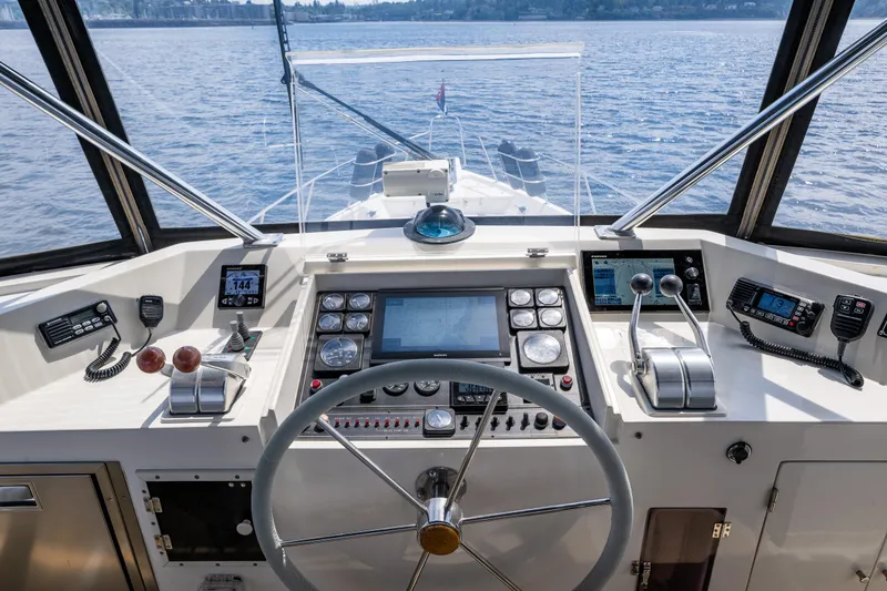 Slide: The Image of Helm of 1997 Offshore Yachts 52 Sedan with navigation controls and panoramic water view. - 47