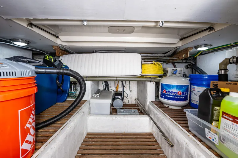 Slide: The Image of Storage area in a 1997 Offshore Yachts 52 Sedan, featuring various equipment and supplies. - 48