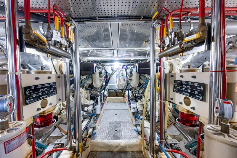 Slide: The Image of Engine room of 1997 Offshore Yachts 52 Sedan, featuring dual engines and complex piping system. - 49