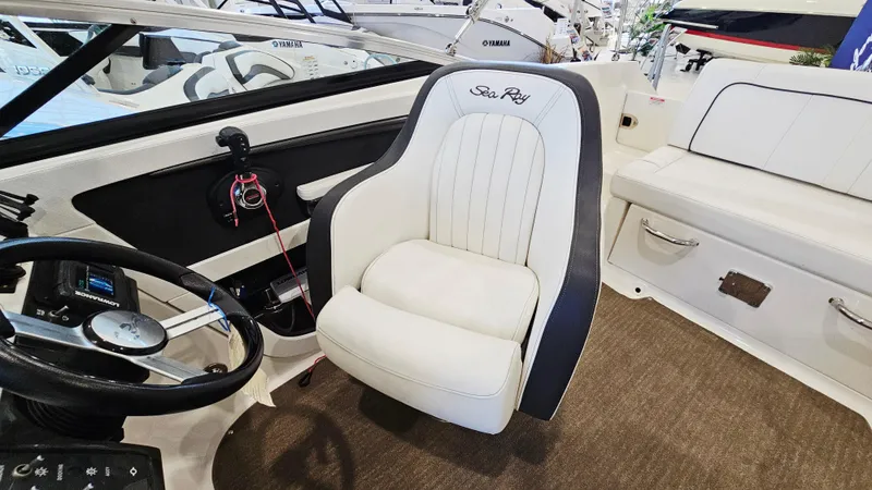 Slide: The Image of 2014 Sea Ray 220 Sundeck Outboard interior with steering wheel and plush seating. - 10