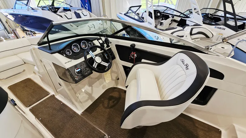 Slide: The Image of 2014 Sea Ray 220 Sundeck Outboard interior with steering wheel and seating. - 11