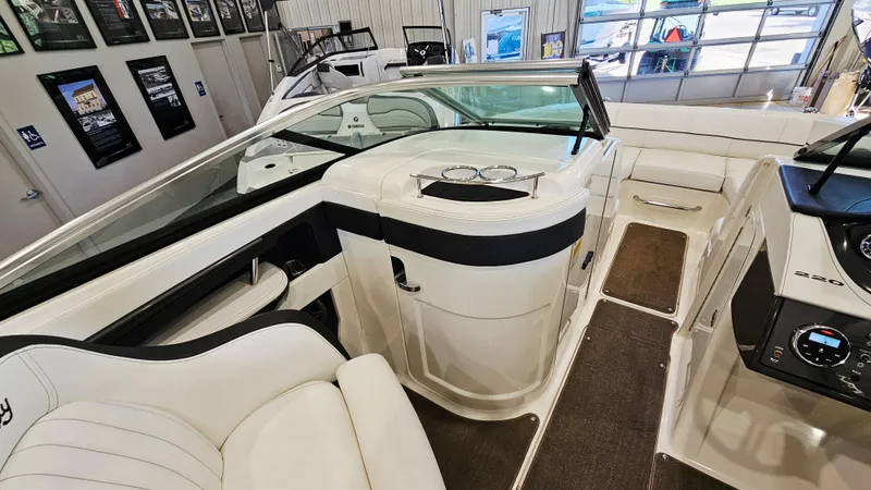 Slide: The Image of 2014 Sea Ray 220 Sundeck Outboard interior with white seating and dashboard. - 14