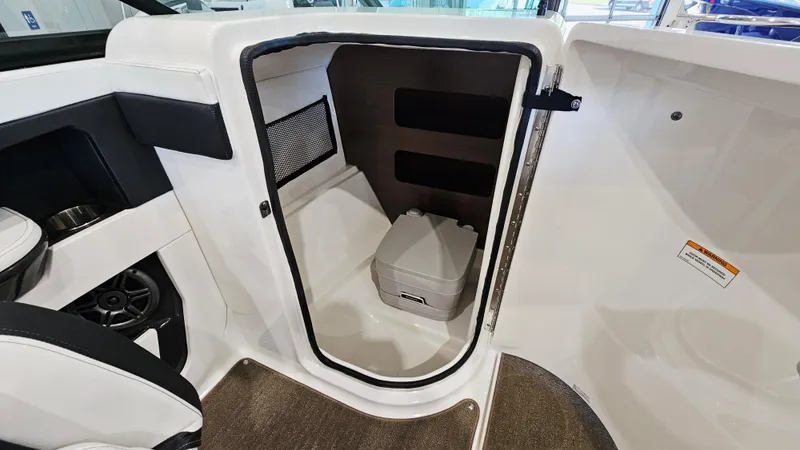 Slide: The Image of 2014 Sea Ray 220 Sundeck Outboard interior with compact marine toilet. - 15