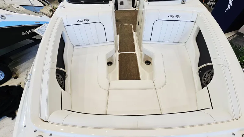 Slide: The Image of 2014 Sea Ray 220 Sundeck Outboard interior with white seating and wood accents. - 17