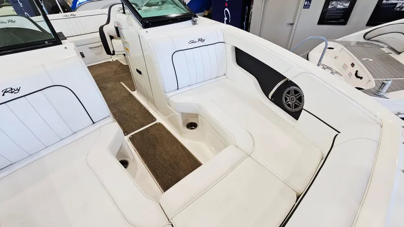 Slide: The Image of 2014 Sea Ray 220 Sundeck Outboard interior with white seating and speaker detail. - 18