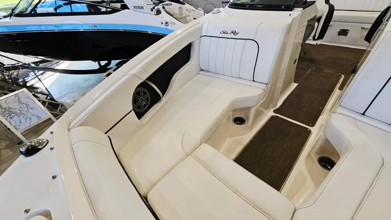 Slide: The Image of 2014 Sea Ray 220 Sundeck Outboard interior with white seating and speaker. - 19