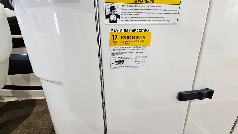 Slide: The Image of 2014 Sea Ray 220 Sundeck Outboard capacity label, maximum 12 persons or 1900 lbs. - 26