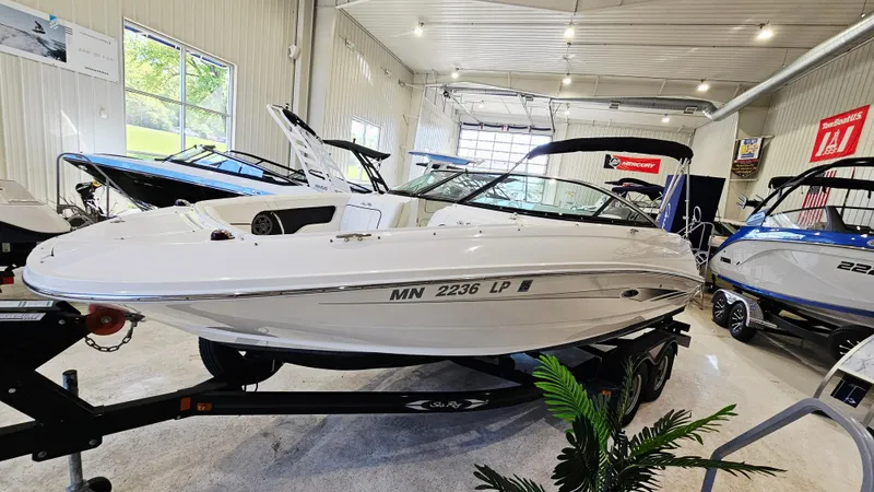 Slide: The Image of 2014 Sea Ray 220 Sundeck Outboard displayed in a showroom on a trailer. - 3