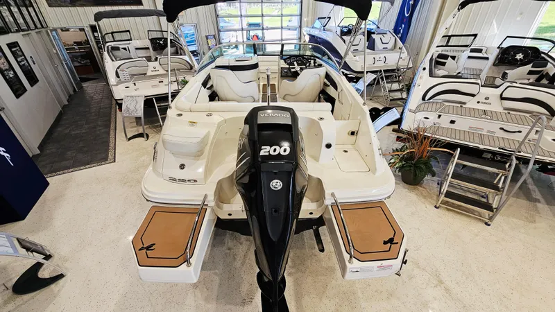 Slide: The Image of 2014 Sea Ray 220 Sundeck Outboard displayed in showroom, rear view. - 5