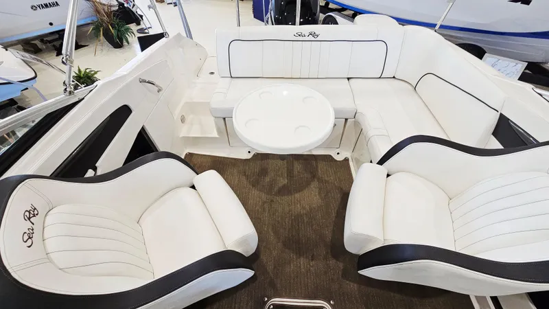 Slide: The Image of 2014 Sea Ray 220 Sundeck Outboard interior with white seating and round table. - 8