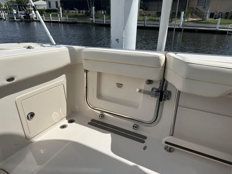 Slide: The Image of 2023 Grady-White Freedom 325 boat interior with seating and storage, docked by the water. - 10