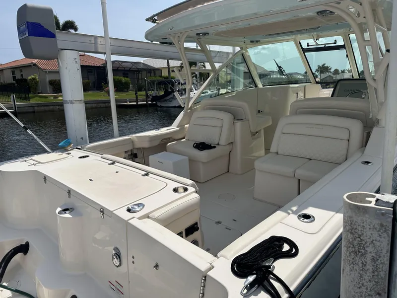 Slide: The Image of 2023 Grady-White Freedom 325 boat with spacious seating, docked by a waterfront home. - 6