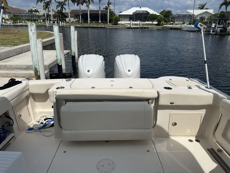 Slide: The Image of 2023 Grady-White Freedom 325 boat docked, featuring dual engines and spacious seating area. - 8