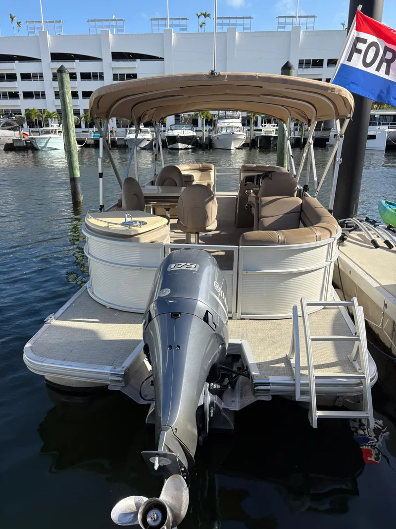 The Image of 2019 Bennington ETW pontoon boat docked, featuring a Yamaha outboard motor and canopy. - 1