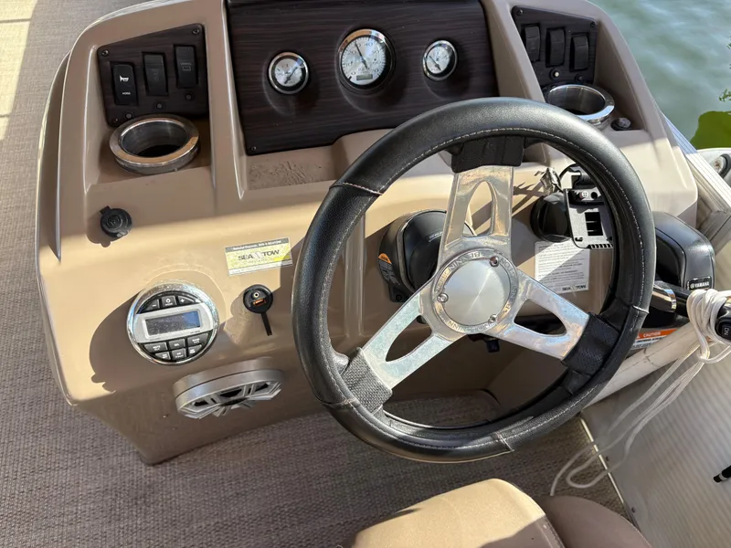 Slide: The Image of Steering wheel and dashboard of a 2019 Bennington ETW boat, featuring gauges and controls. - 5