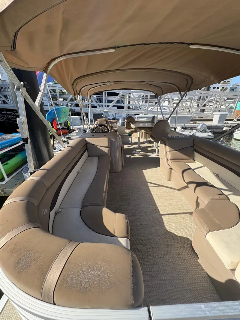 Slide: The Image of 2019 Bennington ETW pontoon boat with spacious seating and canopy, docked at a marina. - 6