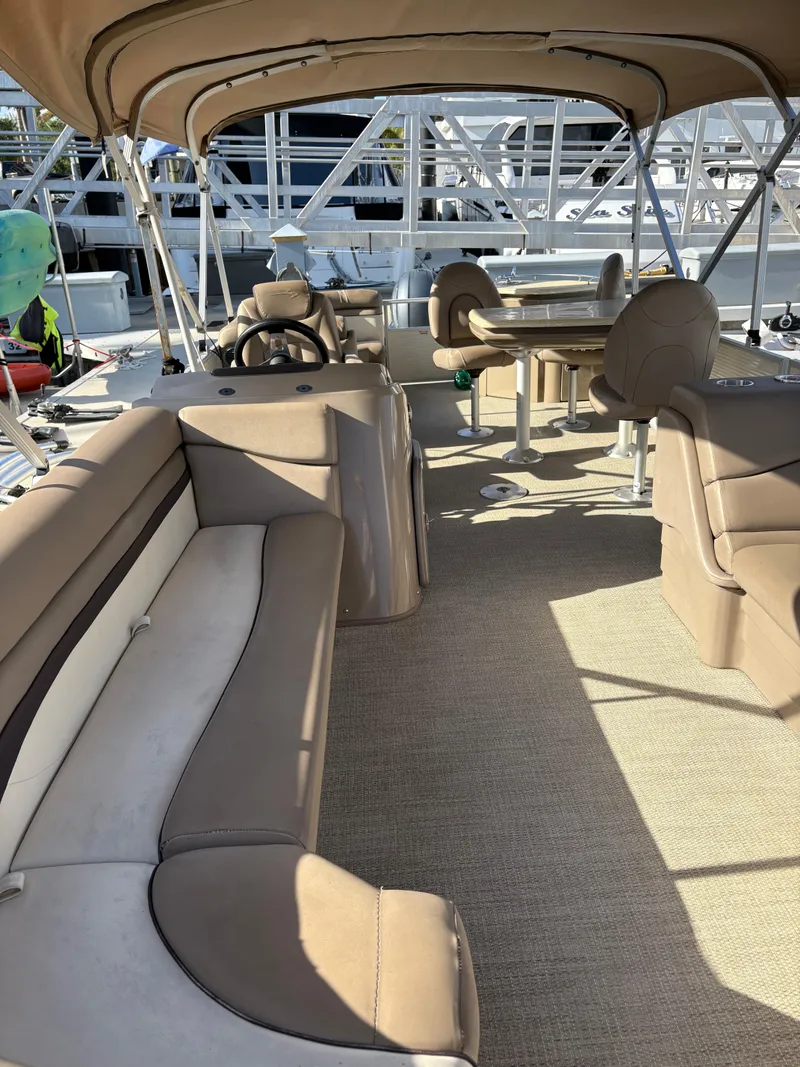 Slide: The Image of 2019 Bennington ETW pontoon boat interior with beige seating and helm. - 7