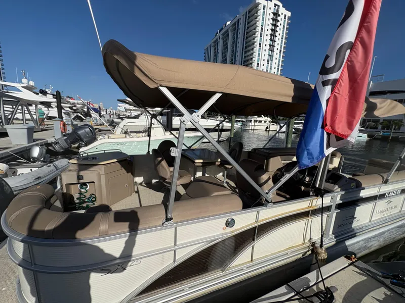 Slide: The Image of 2019 Bennington ETW pontoon boat docked at marina with canopy and flags. - 8