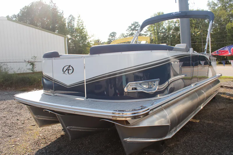 Slide: The Image of 2024 Avalon LSZ Quad Lounger pontoon boat, sleek design, parked outdoors. - 18