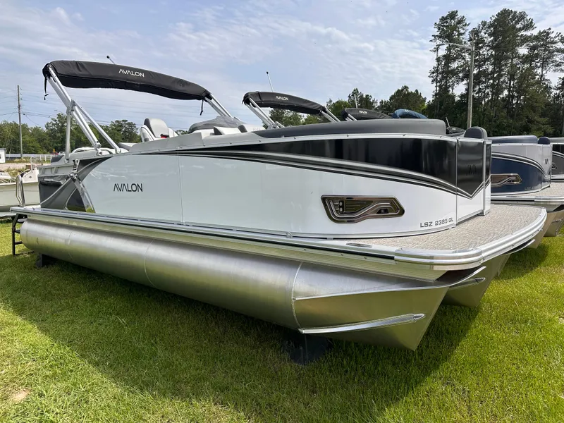 The Image of 2025 Avalon LSZ Quad Lounger pontoon boat on grass, side view. - 0