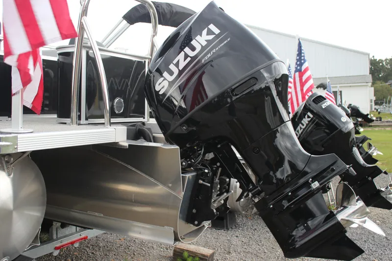 Slide: The Image of 2025 Avalon LSZ Quad Lounger with Suzuki outboard motors and American flags displayed. - 27