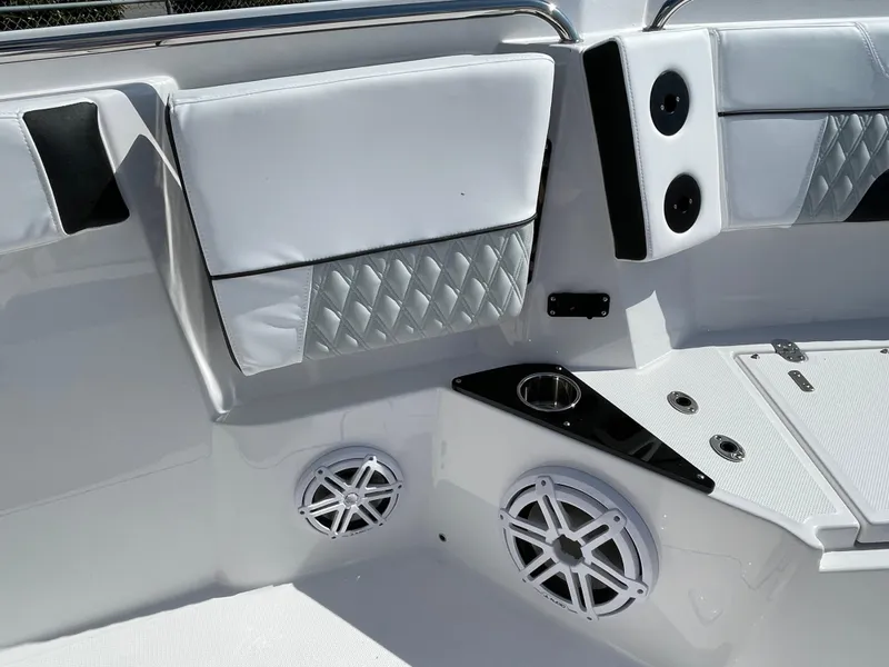Slide: The Image of 2025 Blackfin 272CC boat interior with white seating, speakers, and cup holders. - 15