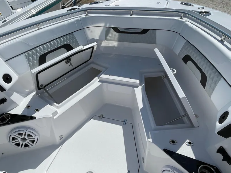 Slide: The Image of 2025 Blackfin 272CC boat interior with open storage compartments and sleek white seating. - 16