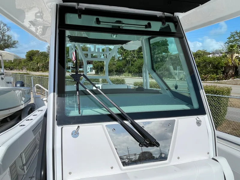 Slide: The Image of 2025 Blackfin 272CC boat windshield with wipers, docked outdoors. - 21