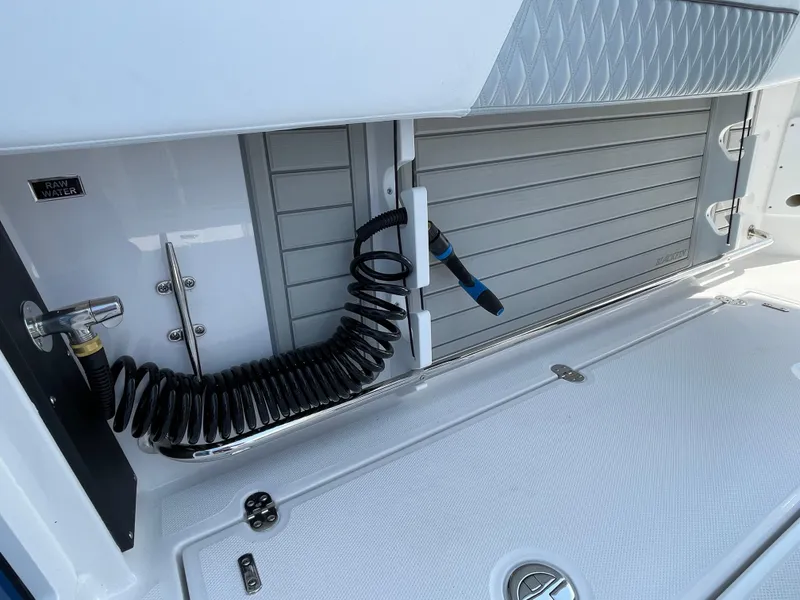 Slide: The Image of 2025 Blackfin 272CC boat deck with coiled hose and storage compartment. - 37