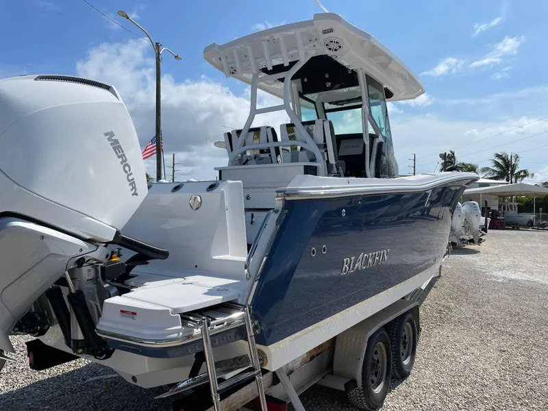 Slide: The Image of 2025 Blackfin 272CC boat with Mercury engine, parked on a trailer under a clear sky. - 41