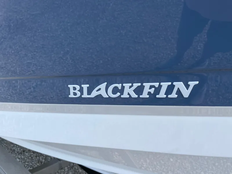 Slide: The Image of 2025 Blackfin 272CC boat logo on blue and white hull. - 5