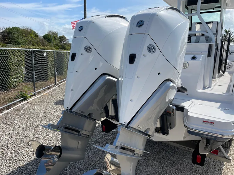 Slide: The Image of 2025 Blackfin 272CC boat with dual outboard engines, parked on gravel. - 8