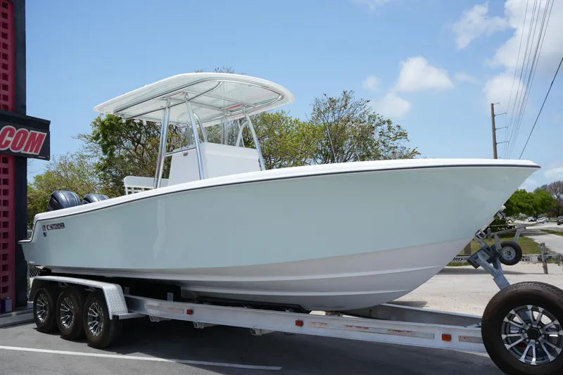 The Image of 2025 Contender 28T boat on trailer, parked outdoors under clear sky. - 0