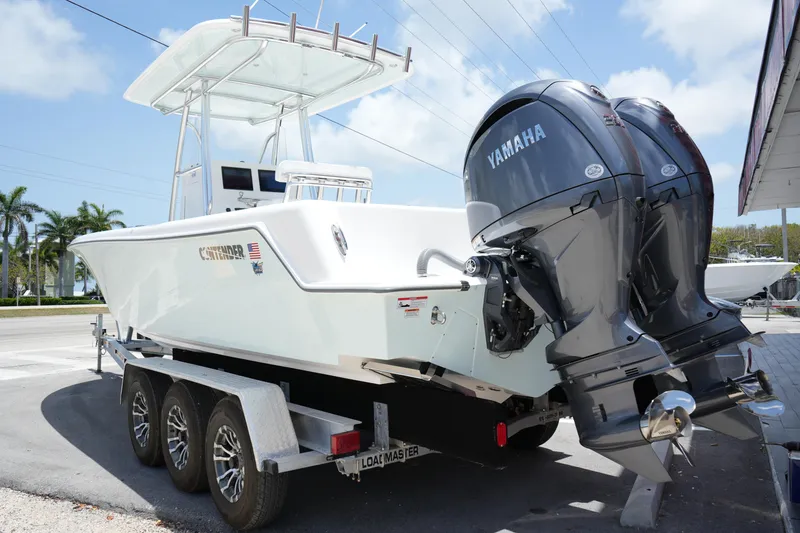 Slide: The Image of 2025 Contender 28T boat on trailer with dual Yamaha engines, parked outdoors. - 2