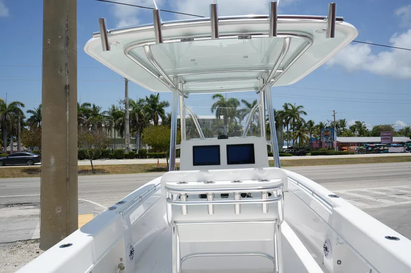 Slide: The Image of 2025 Contender 28T boat with dual screens and T-top, parked near palm trees. - 3