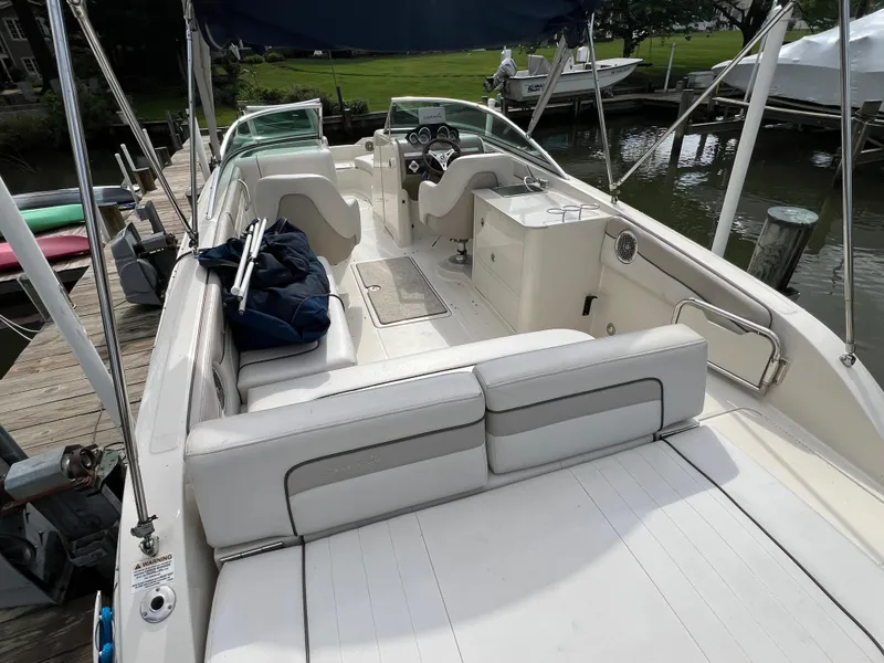 Slide: The Image of 2010 Sea Ray 280 Sundeck boat with spacious seating and helm, docked by the water. - 8