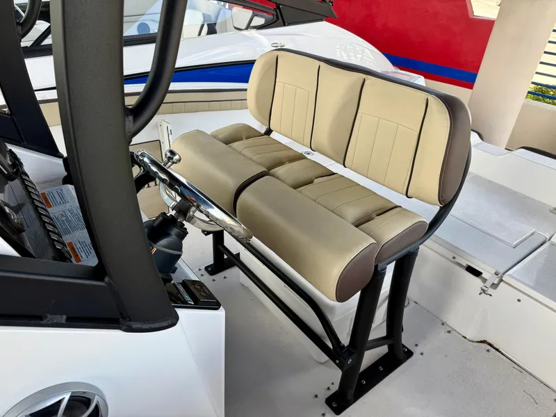 Slide: The Image of 2024 Yamaha Boats 255 FSH Sport H helm seat with beige upholstery and steering wheel. - 5