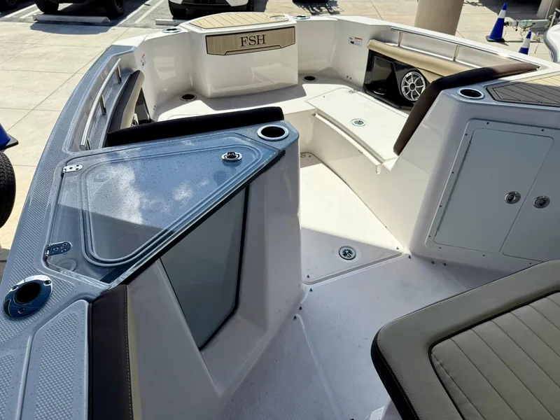 Slide: The Image of 2024 Yamaha Boats 255 FSH Sport H interior with seating and storage compartments. - 6