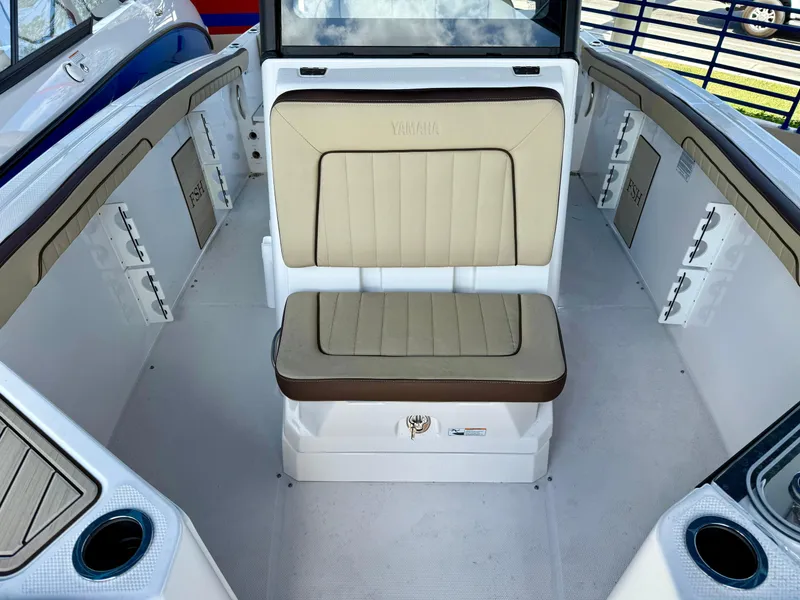 Slide: The Image of 2024 Yamaha Boats 255 FSH Sport H interior with beige seating and storage compartments. - 8