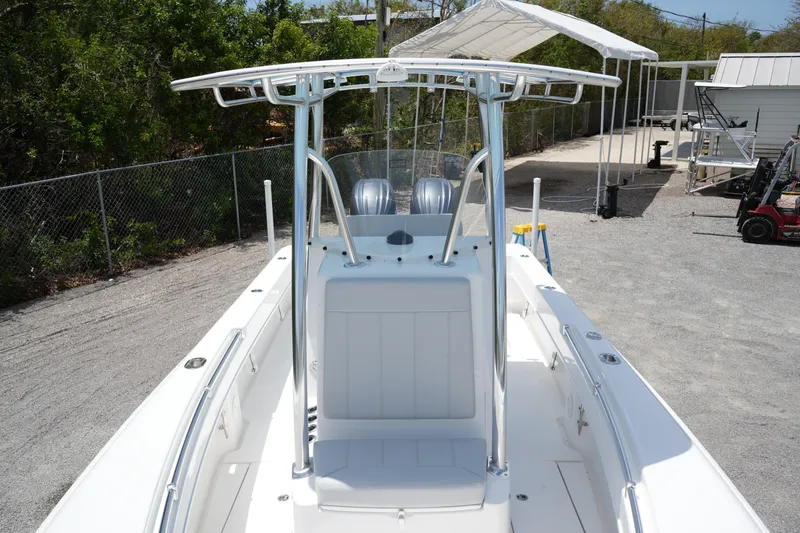 Slide: The Image of 2025 Contender 25T boat with dual engines, white deck, and T-top in a gravel lot. - 17