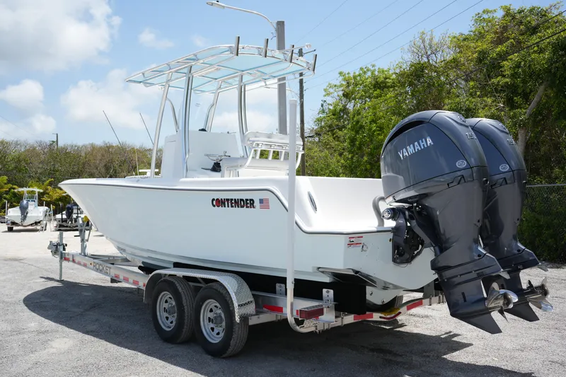 Slide: The Image of 2025 Contender 25T boat on trailer with dual Yamaha engines, parked outdoors. - 2