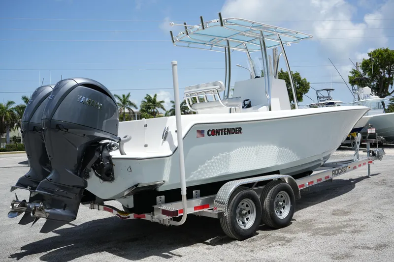 Slide: The Image of 2025 Contender 25T boat on trailer with dual engines, parked outdoors. - 3