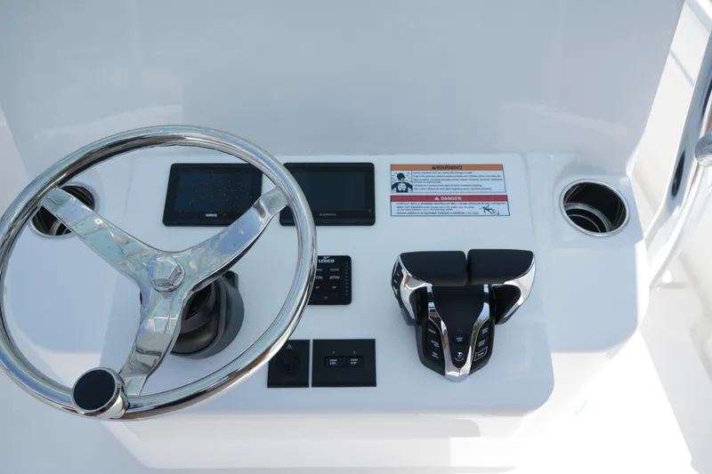 Slide: The Image of 2025 Contender 25T boat helm with steering wheel and controls. - 8