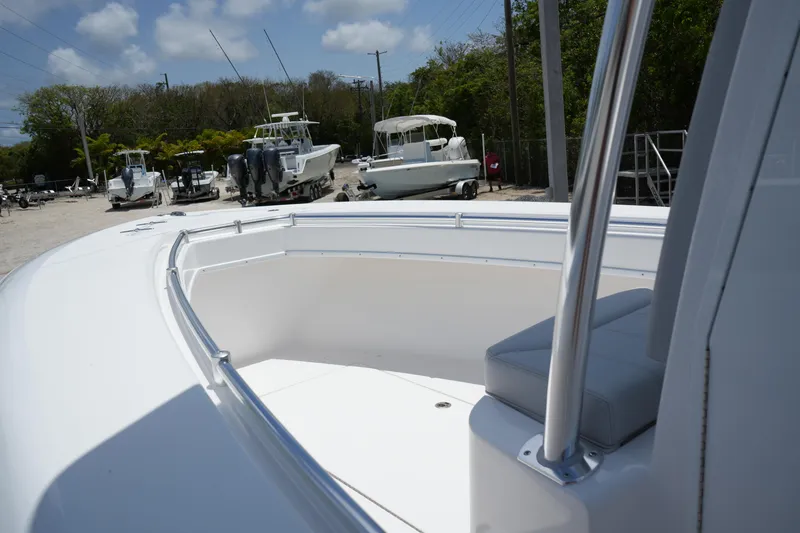 Slide: The Image of 2025 Contender 25T boat, white deck, parked among other boats, sunny day. - 9