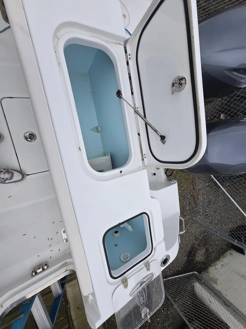 Slide: The Image of 2020 Sea Hunt Gamefish 25 boat with open storage compartments. - 12