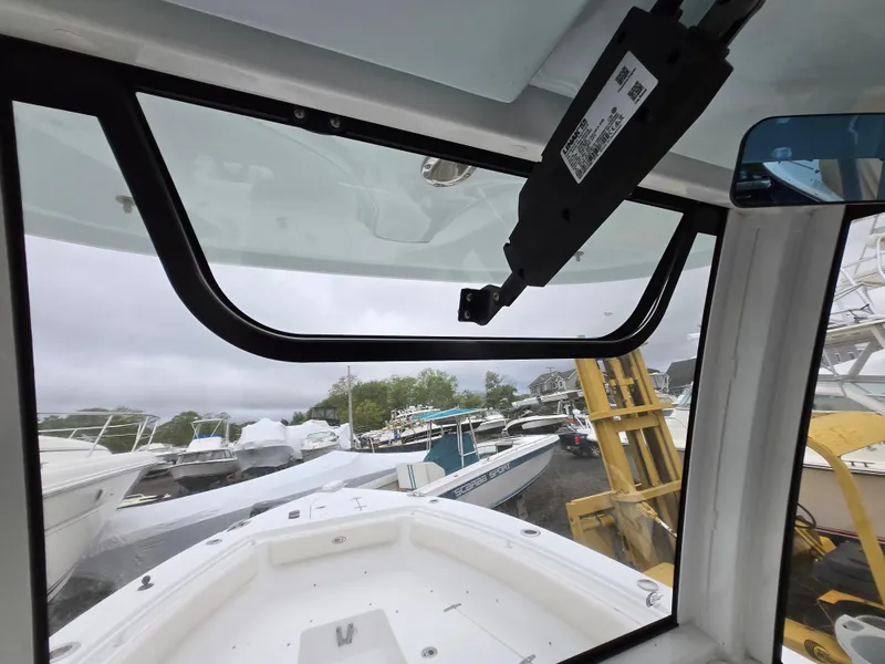 Slide: The Image of 2020 Sea Hunt Gamefish 25 boat interior view with docked vessels in background. - 18