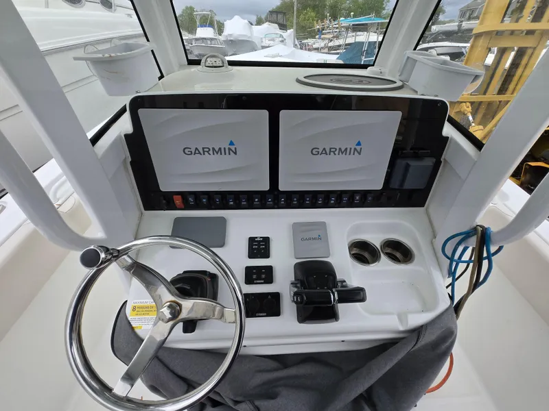 Slide: The Image of 2020 Sea Hunt Gamefish 25 dashboard with Garmin displays and steering wheel. - 2